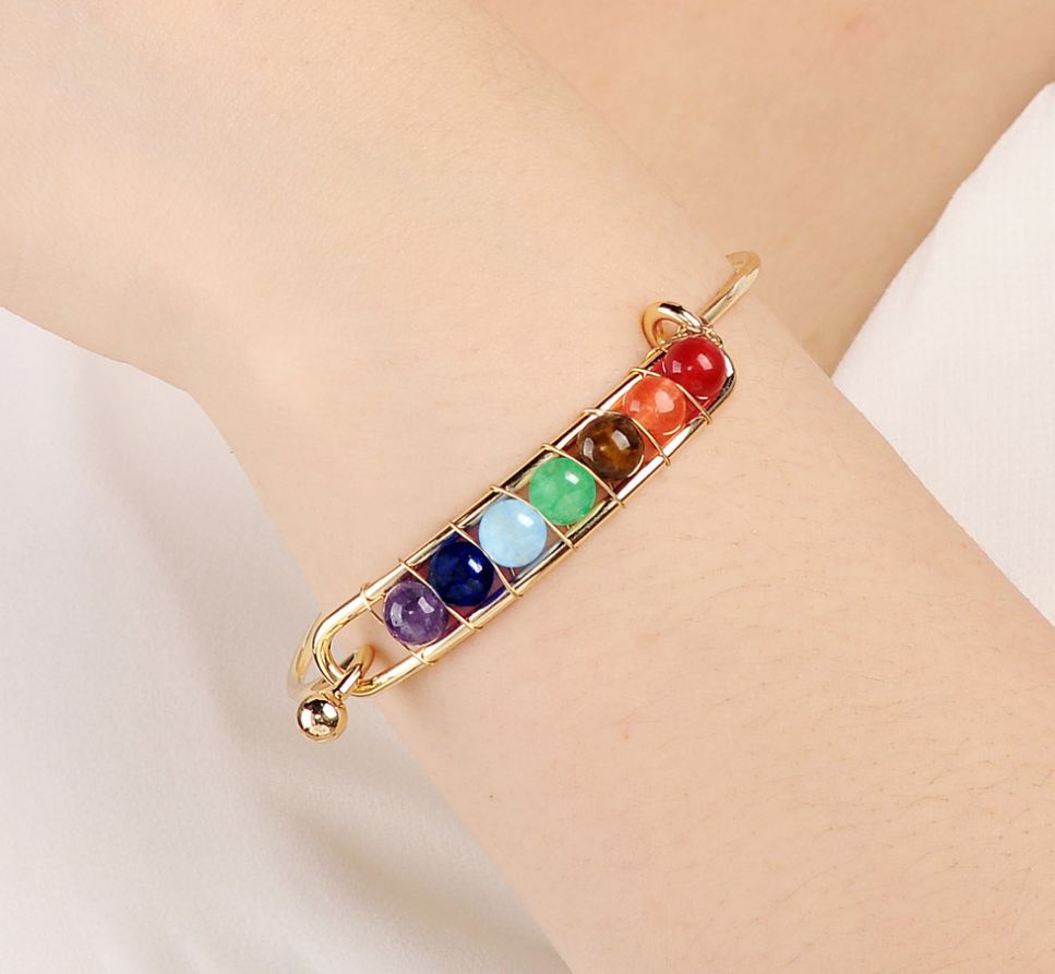 Close-up of hand woven chakra bracelet with spherical stones